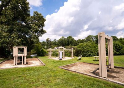 A serene park featuring a playground for children and benches for relaxation amidst lush greenery